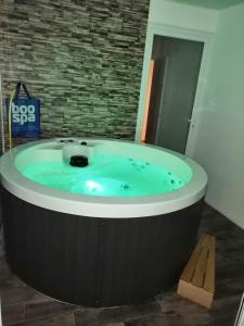 a jacuzzi tub in a room with a brick wall at Villa bord de mer avec piscine et jacuzzi in Pénestin