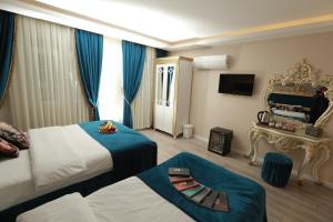 a hotel room with two beds and a chair at Constantinopolis Hotel in Istanbul