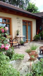 un patio con mesa, sillas y flores en Apartment mit Gartenblick, en Eckersdorf