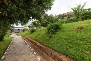 a brick path leading down a grassy hill at KSTDC Mayura Durg Chitradurga in Chitradurga
