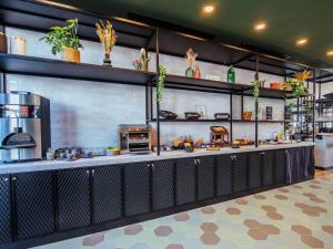 a restaurant kitchen with a counter with a stove at Ibis Styles Rouen Centre Rive Gauche in Rouen
