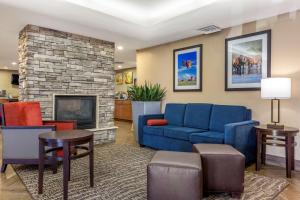 a living room with a blue couch and a fireplace at Comfort Inn & Suites Phoenix North - Deer Valley in Phoenix