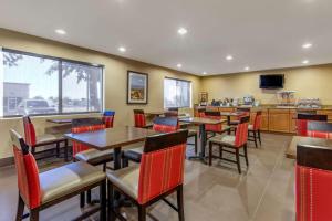 um restaurante com mesas e cadeiras e uma televisão em Comfort Inn & Suites Phoenix North - Deer Valley em Phoenix