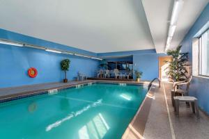 a swimming pool in a building with blue walls at Comfort Inn & Suites Lees Summit - Kansas City in Lees Summit