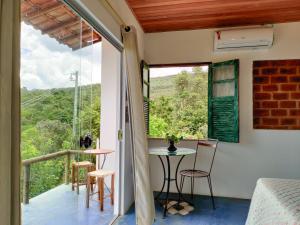 a room with a balcony with a table and chairs at Lençóis Apartamento Suíte Master Green in Lençóis