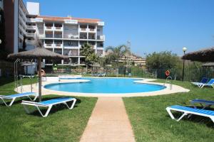 a swimming pool with two lawn chairs and umbrellas at Casa del Sol in Manilva