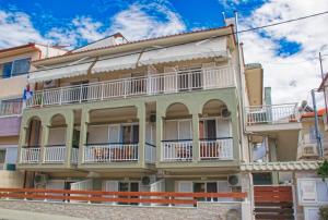 un condominio con balconi bianchi su una strada di Villa Pirofani a Sárti