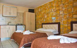 a hotel room with two beds and a kitchen at Villa Pirofani in Sarti
