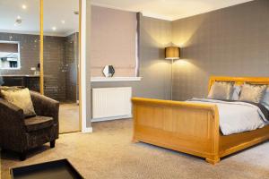a bedroom with a bed and a chair in a room at Forth Apartments in Kirkcaldy