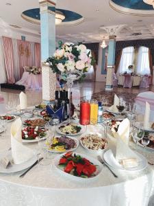 a table with plates of food and flowers on it at Hotel Golden Night in Kaliningrad