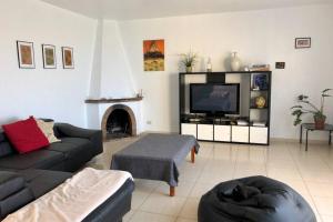 a living room with a couch and a tv at Casa con piscina privada. Mirador de Humbolt. in Santa Úrsula