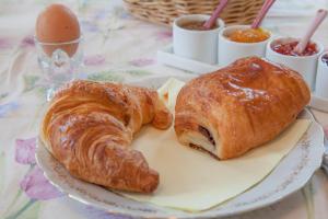 twee croissants en een ei op een bord op een tafel bij Chateau de Moulin le Comte in Aire-sur-la-Lys