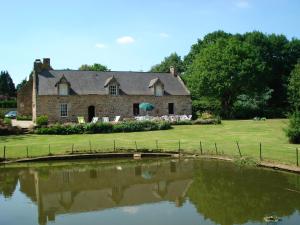 an old stone house with a pond in front of it at Gite de Cohignac in Berric