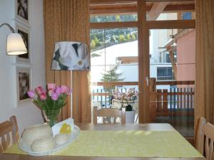 a dining room with a table with a vase of flowers on it at Appartement Gurgl in Obergurgl