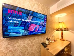 a flat screen tv hanging on a wall in a hotel room at La Rocca Boutique Hotel in Craiova