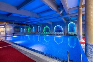 einen Pool in einem Hotel mit Stühlen und Beleuchtung in der Unterkunft Aqua Spa Termale in Novi Pazar