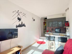 een woonkamer met een tv en een keuken bij ISOLA Front de Neige - STUDIO in Isola 2000