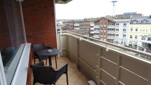 a balcony with two chairs and a table on a building at Nordsee Residenz Appartement 60 in Westerland (Sylt)
