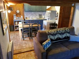 a living room with a couch and a kitchen at Petit chalet savoyard in Domancy