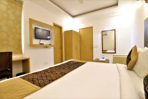 a hotel room with a large bed and a tv at Hotel Aeropath Near IGI Airport Delhi in New Delhi