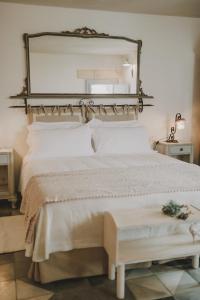 een slaapkamer met een grote spiegel boven een bed bij Masseria Montenapoleone in Fasano