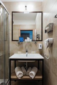 a bathroom with a sink and a mirror at Hotel 32 Kraków Old Town in Krakow