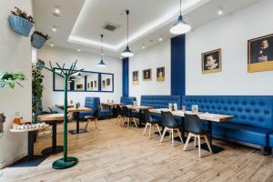 a restaurant with blue walls and tables and chairs at Hotel 32 Kraków Old Town in Krakow