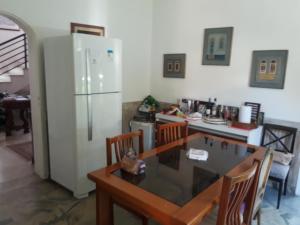 a kitchen with a table and a refrigerator at LA Jolla Suítes Alto da Lapa in Sao Paulo