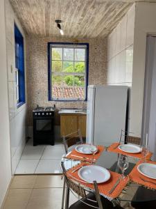 eine Küche mit einem Tisch mit Stühlen und einem Kühlschrank in der Unterkunft Loft Largo do Ó in Tiradentes