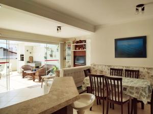 uma cozinha e sala de jantar com mesa e cadeiras em Cobertura em Canasvieiras - Vista para o Mar - 50 mtrs da Praia - Centro Canasvieiras em Florianópolis