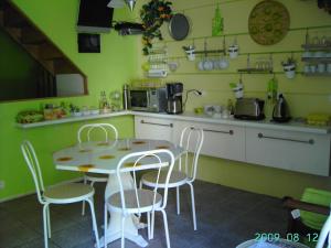 a kitchen with a table and chairs in a kitchen at Chambres d'Hôtes Au Grillon Dort in Moustey