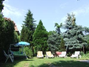 a group of chairs and an umbrella in a yard at Anikó Apartman in Hévíz