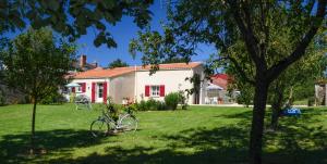 una casa con una bicicleta estacionada en el patio en gîtes de l'Hôpiteau, en LʼOie