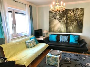 ein Wohnzimmer mit einem Sofa und einem Kronleuchter in der Unterkunft Ferienwohnung Eder in Pöcking