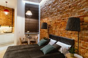 a brick wall in a bedroom with a bed and a table at Kamienica1899 in Szczecin