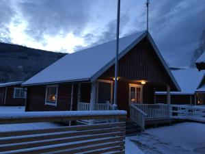 a cabin with a snow covered roof in the snow at Vildmarkscenter in Sysslebäck