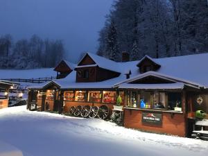 un bâtiment recouvert de neige avec des lumières sur lui dans l'établissement Chata Wuja Toma, à Szczyrk