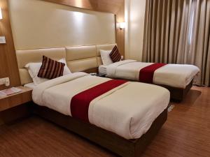 a hotel room with two beds and a couch at Hotel Middle Path & Spa in Pokhara