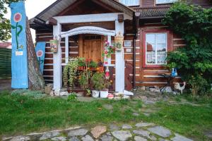 a wooden cabin with a door and flowers in front of it at Wczasowisko Międzywodzie in Międzywodzie