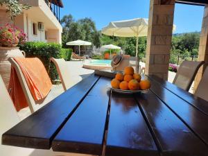 un plato de naranjas sentado en una mesa de madera en Villa Maragoudi en Arménoi