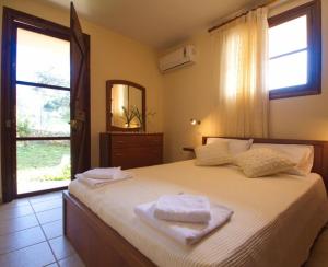 a bedroom with a bed with two towels on it at Villa Maragoudi in Arménoi