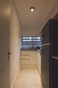 uma pequena cozinha com um frigorífico e uma janela em A Metros del Parana em Rosário