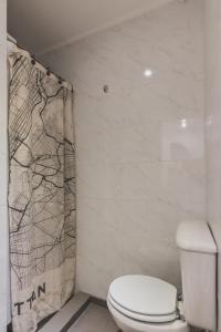 Un baño con inodoro y cortina de ducha. en A Metros del Parana, en Rosario