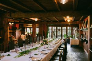 una mesa larga en una habitación con vasos y flores en La Moncloa de San Lazaro en Cacabelos