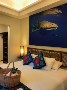 a bedroom with a bed with a whale painting on the wall at Casa Azul Maya in Isla Mujeres