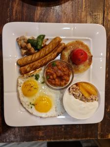 a plate of breakfast food with eggs sausage and beans at Hotel Middle Path & Spa in Pokhara