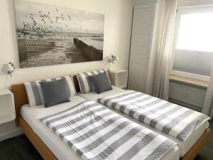 um quarto com duas camas e um quadro na parede em Sola-Bona-Wohnung-29 em Westerland