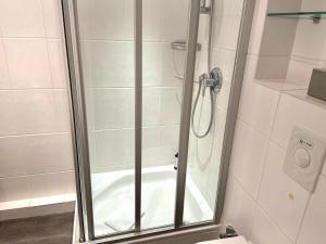 um chuveiro com uma porta de vidro na casa de banho em Sola-Bona-Wohnung-29 em Westerland