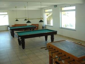a room with a table, chairs, and a pool table at Ericeira Camping & Bungalows in Ericeira