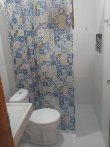 y baño con aseo y cortina de ducha. en Jangadas do Pontal en Fortim
